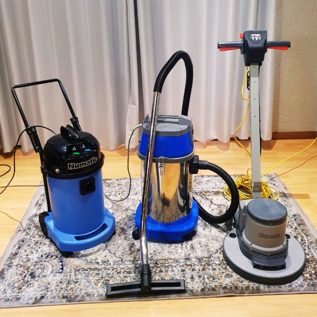 Professional carpet and floor cleaning equipment by Clean Route Services, featuring Numatic vacuum cleaners and floor scrubber on patterned rug